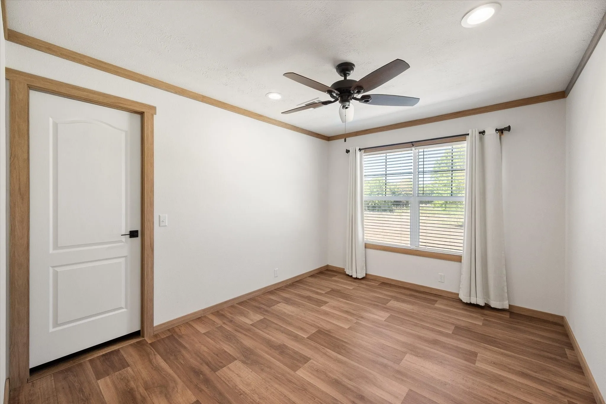 Bright secondary bedroom (2) offers neutral finishes, ceiling fan, natural light and convenient closet access.
