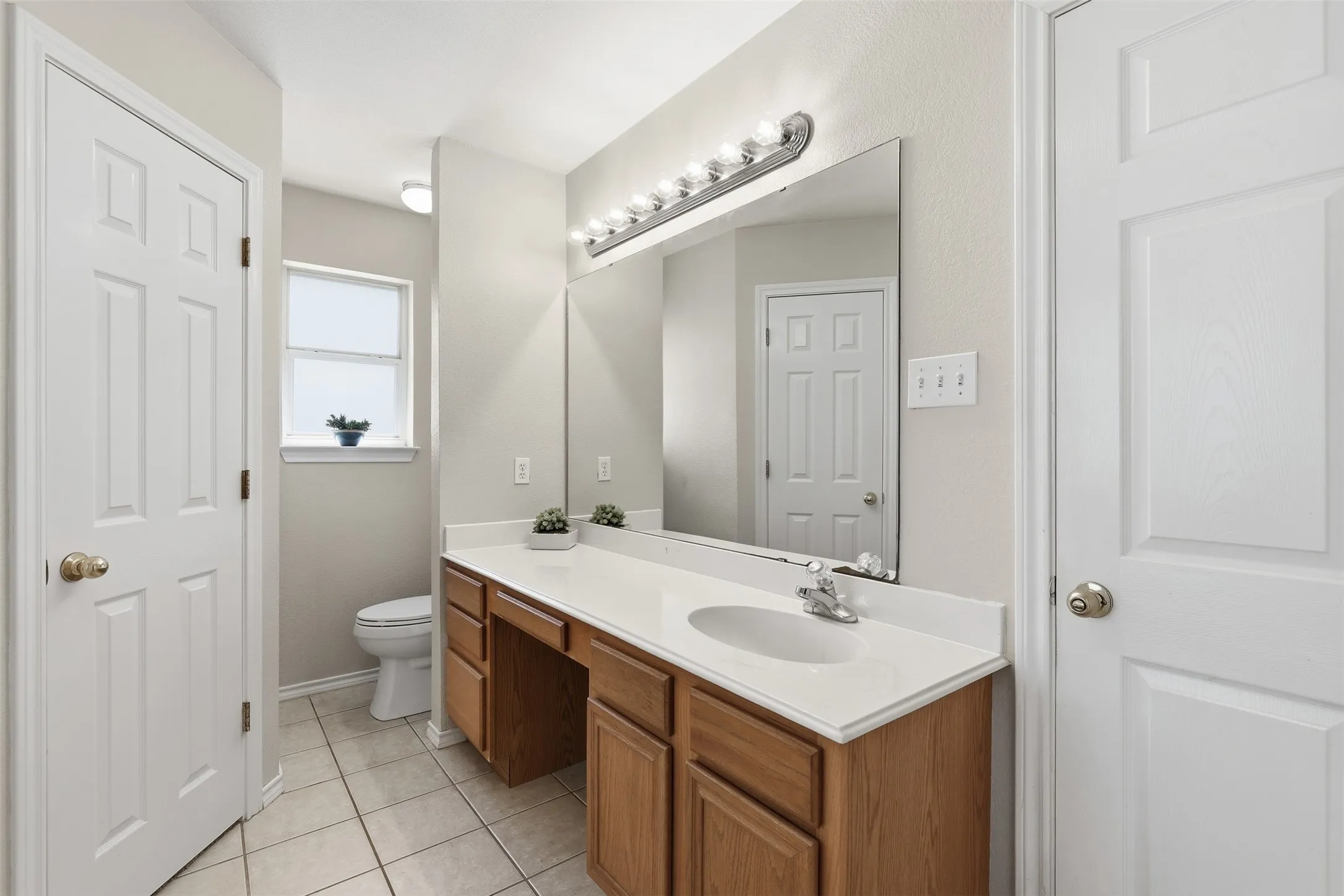 Wood-finish vanity with an integrated sink and light-toned countertop