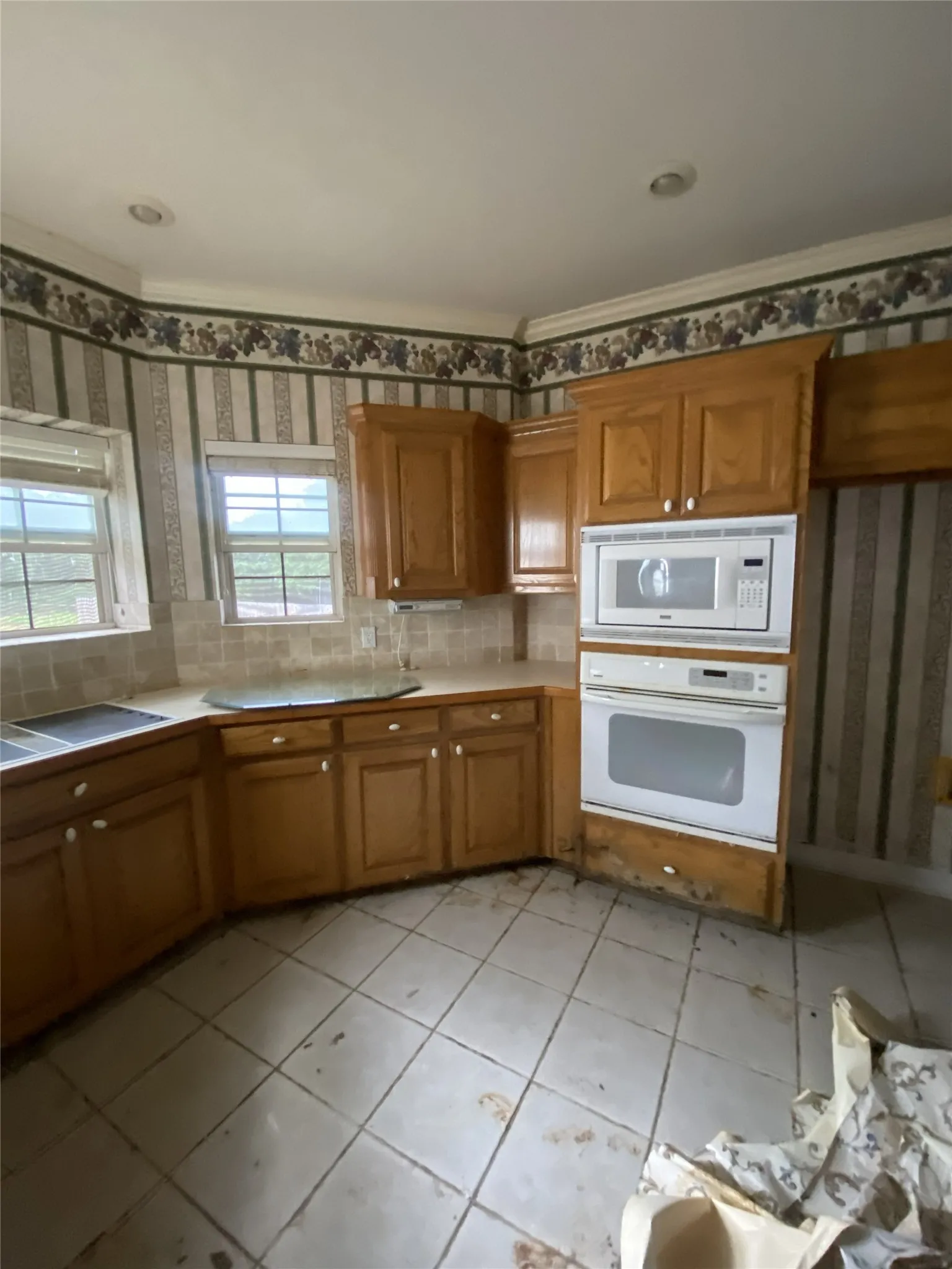 Galley kitchen with wood-finish cabinetry, built-in wall oven, and recessed lighting