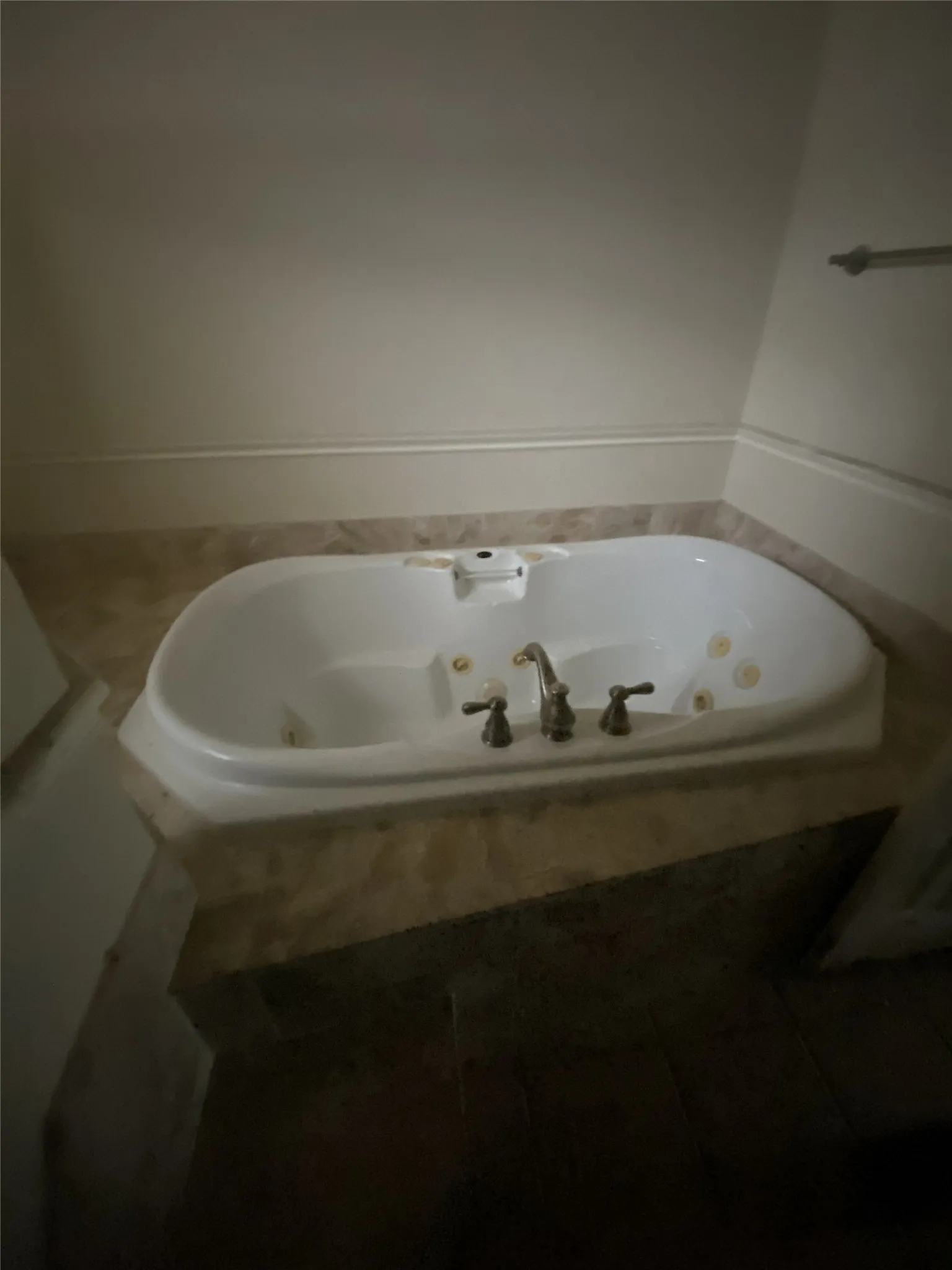 Built-in jetted tub with deck-mounted faucet and tile surround