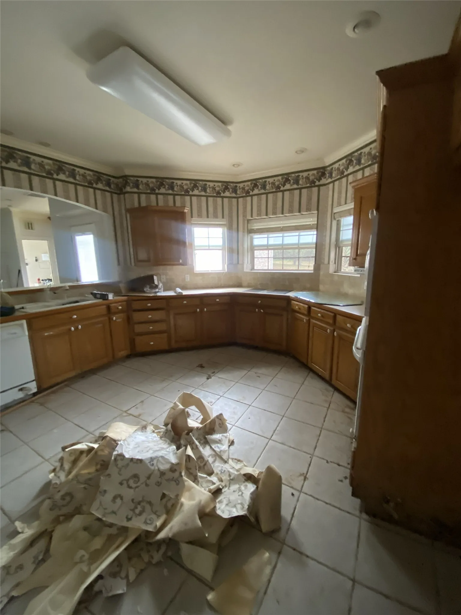 Kitchen featuring wood-finish cabinetry, tile flooring, and recessed lighting