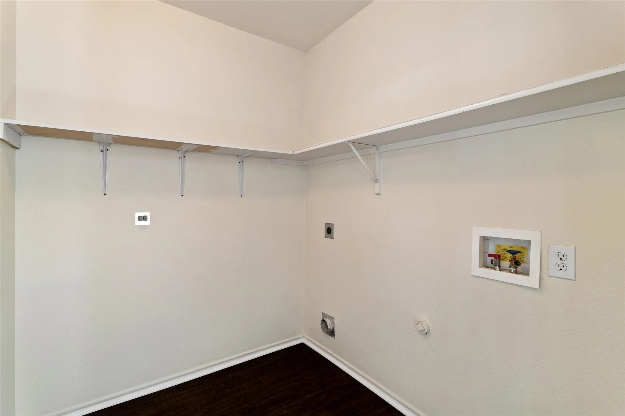 Washroom featuring electric dryer hookup, washer hookup, and dark wood finished floors