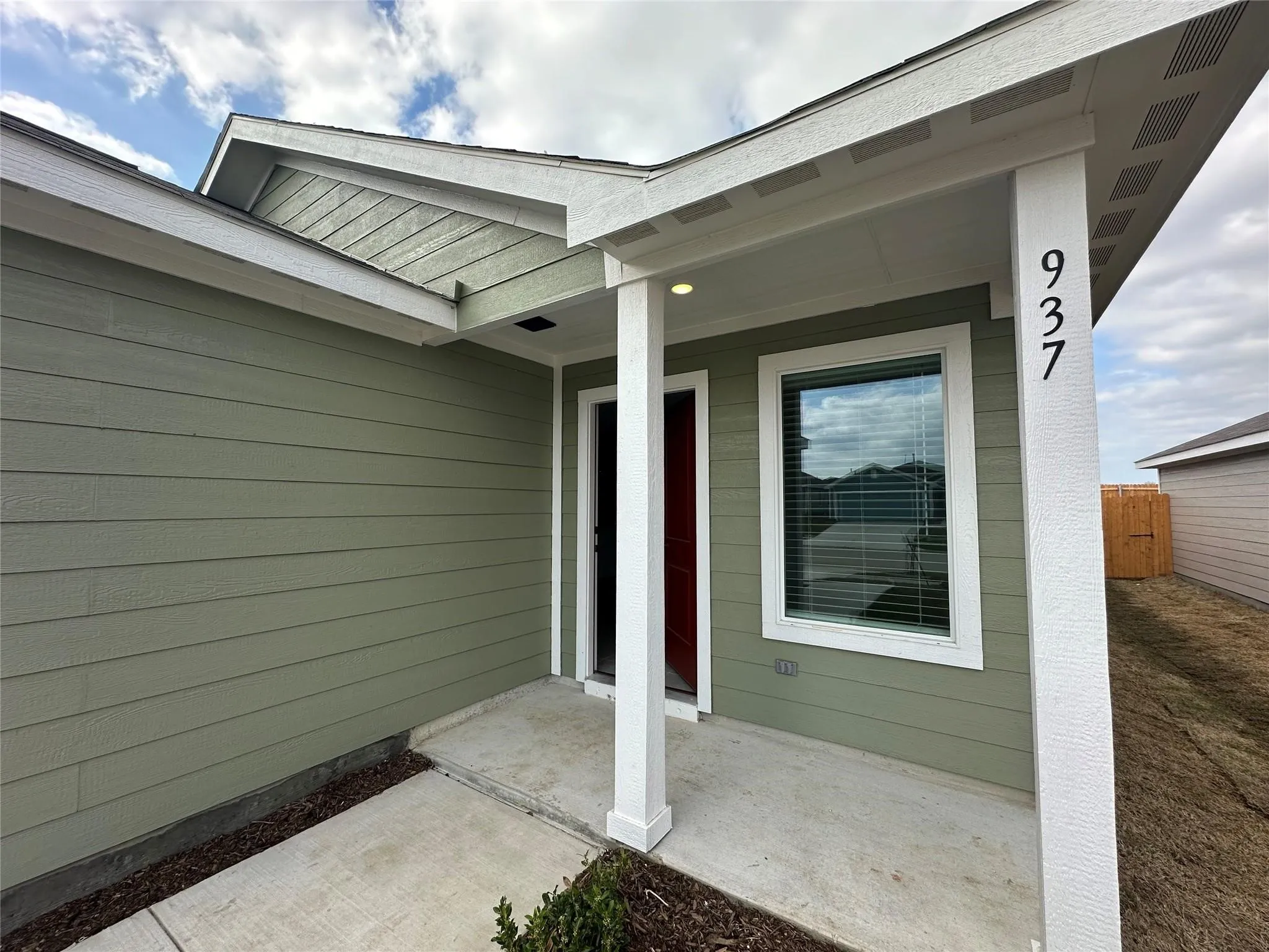 Entryway featuring a covered porch, recessed lighting, and a red door