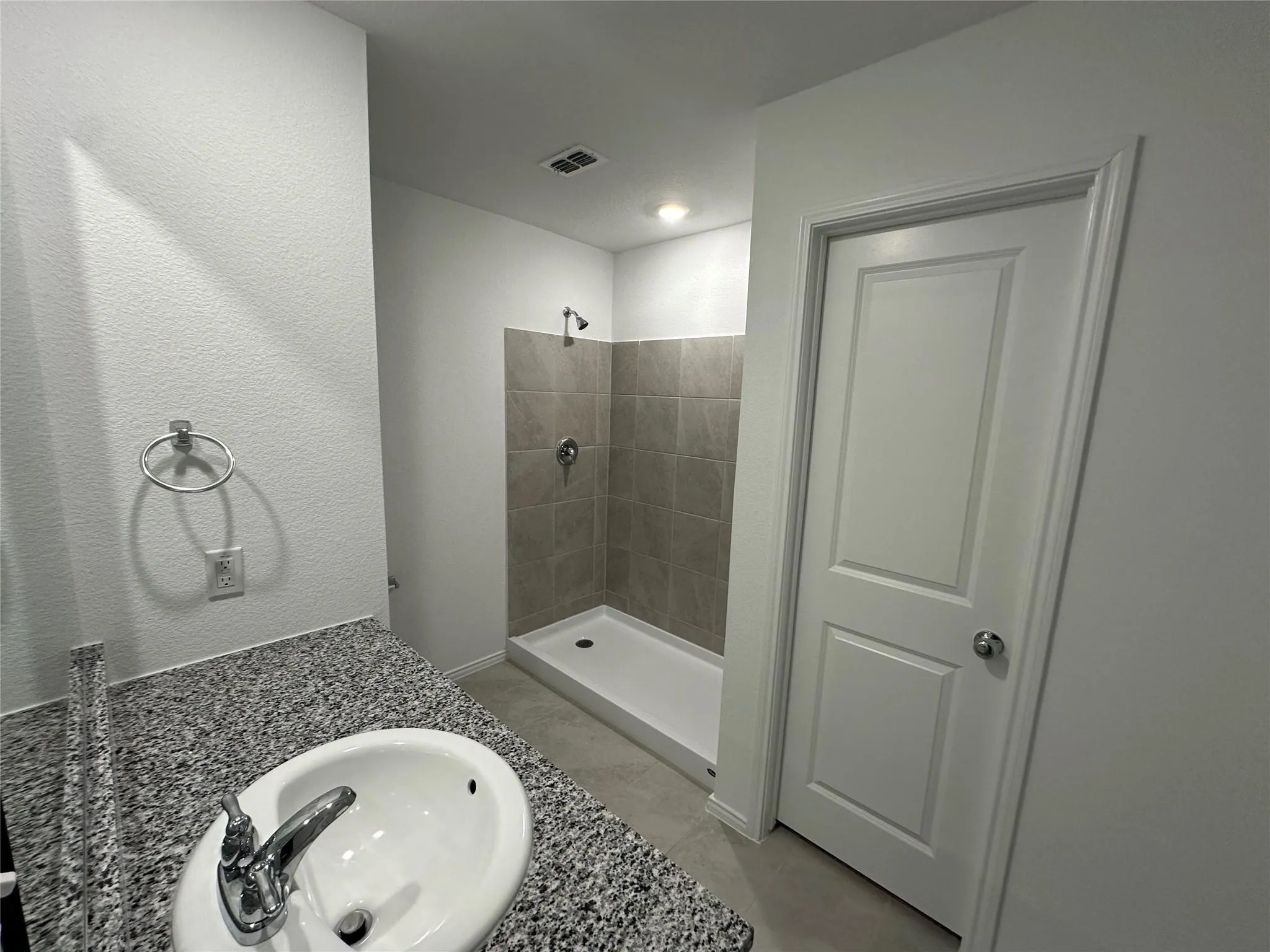 Bathroom vanity with a speckled countertop and an undermount sink