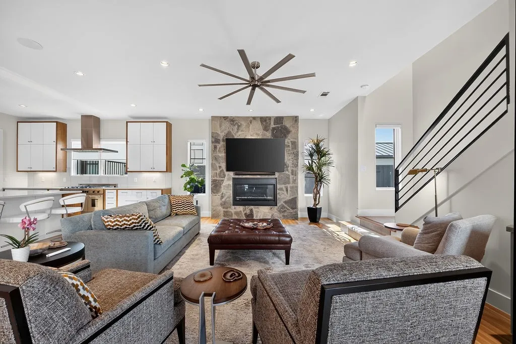 Anchored by a stone fireplace, the central family room opens directly to the outdoor spaces through sliding glass doors