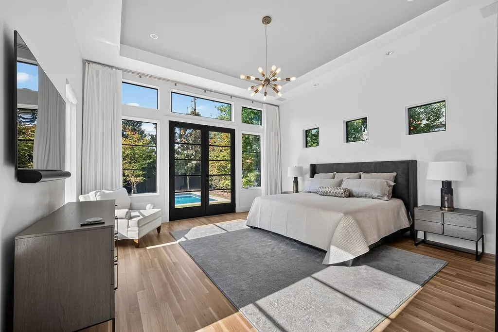 Tucked away on the main floor, the primary suite features white oak floors and views of the backyard