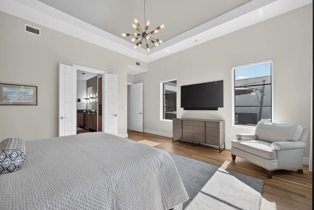 With Hunter Douglas power blinds and ample space for a sitting area, this bedroom balances practical convenience with calm energy