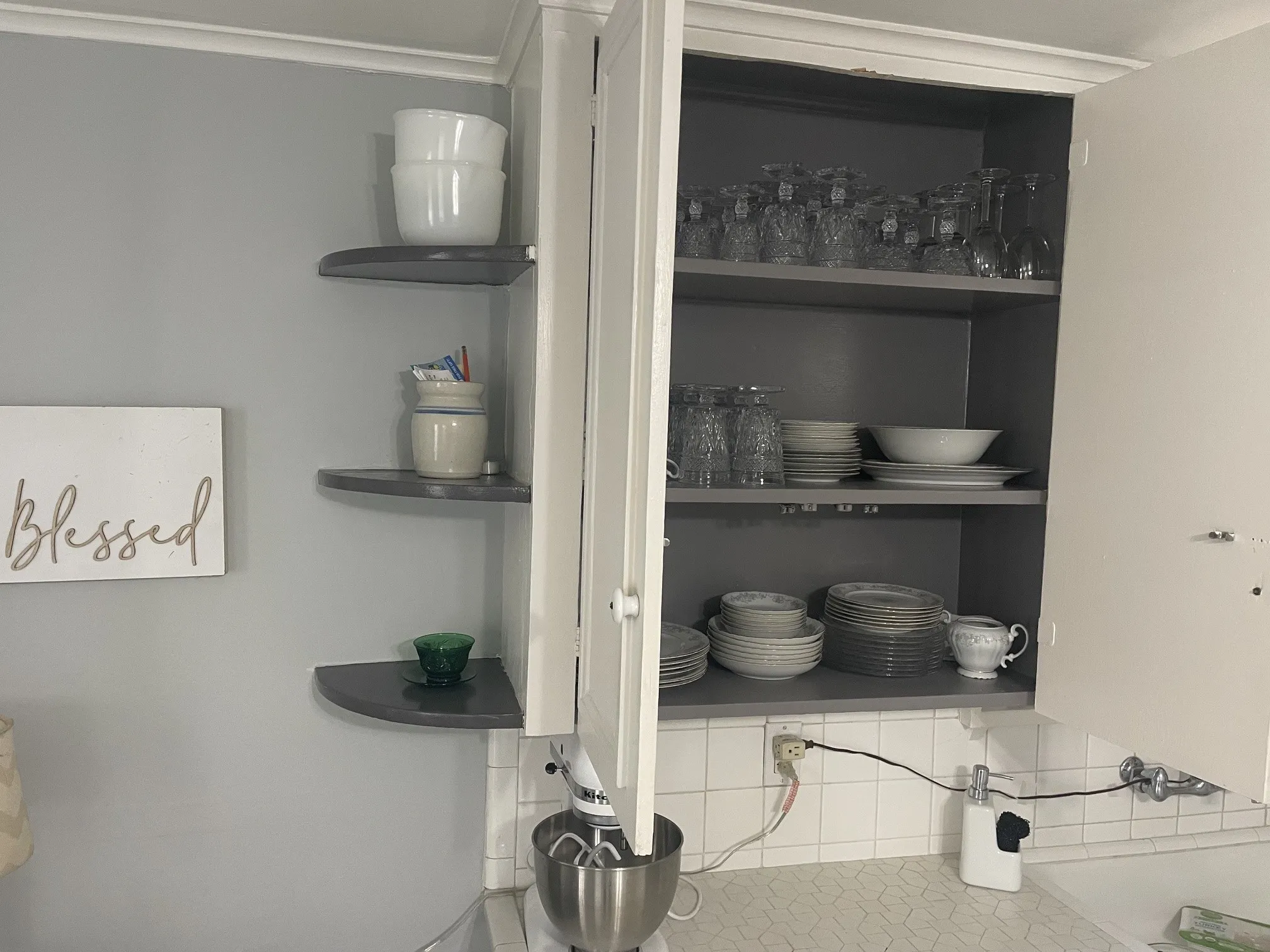 Built-in cabinetry with interior shelving, corner floating shelves, and a tiled backsplash