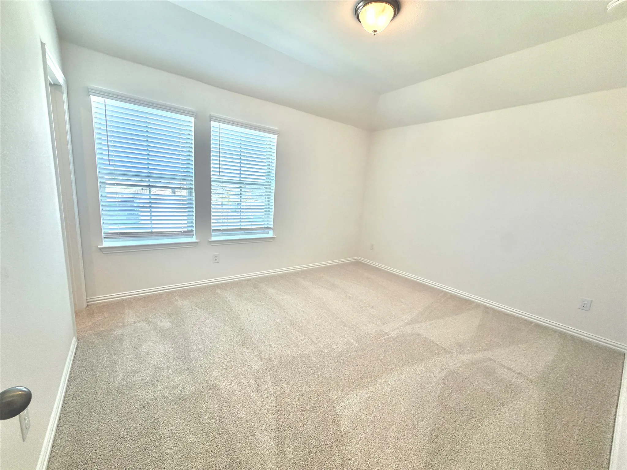 Recessed ceiling, neutral-toned walls, and plush carpeting