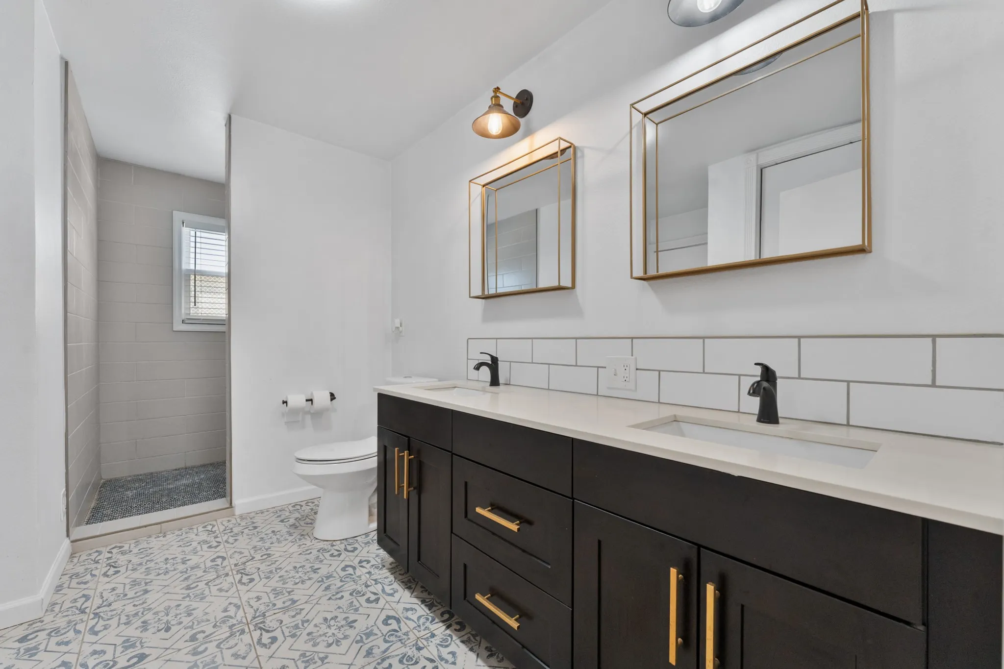 Dual vanity with dark wood-finish cabinetry and gold-tone hardware