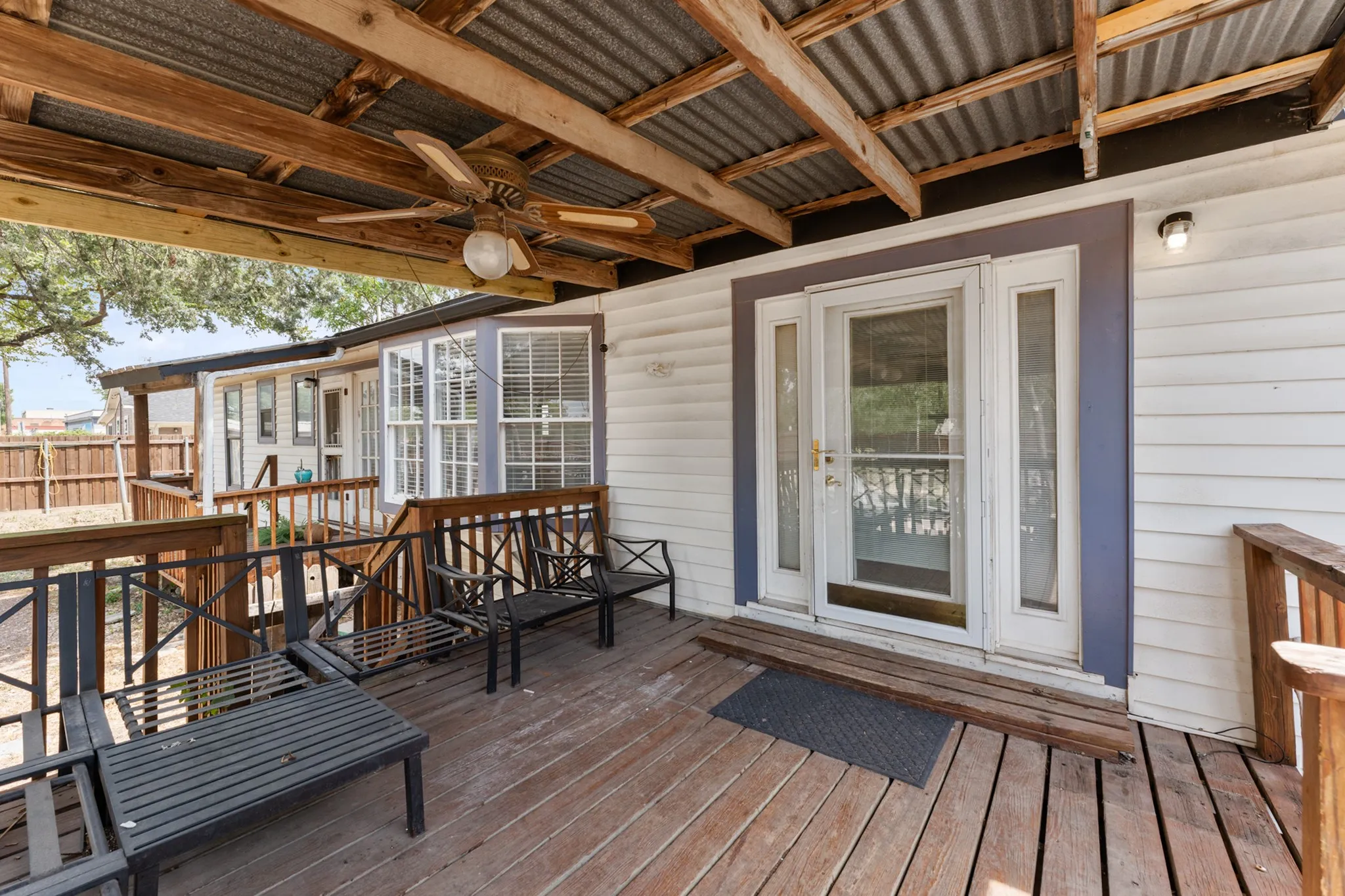 Covered deck with wood-finish flooring, exposed beam ceiling, and ceiling fan