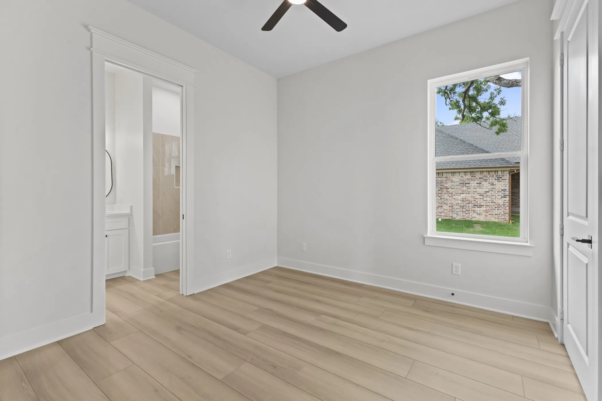 Wood-finish flooring, white walls, and a ceiling fan