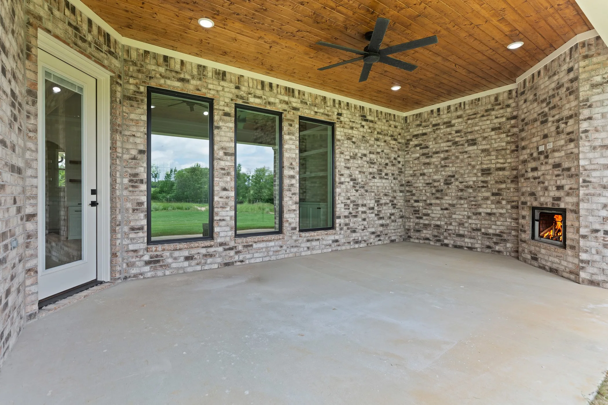 Covered patio featuring a brick exterior and a wood-finish ceiling