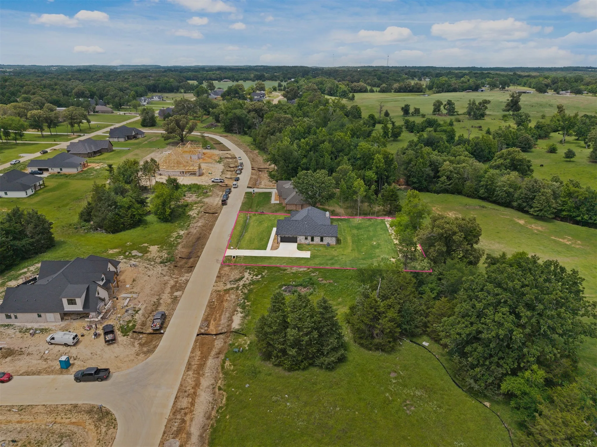Expansive lot featuring a newly constructed residence with a dark roof