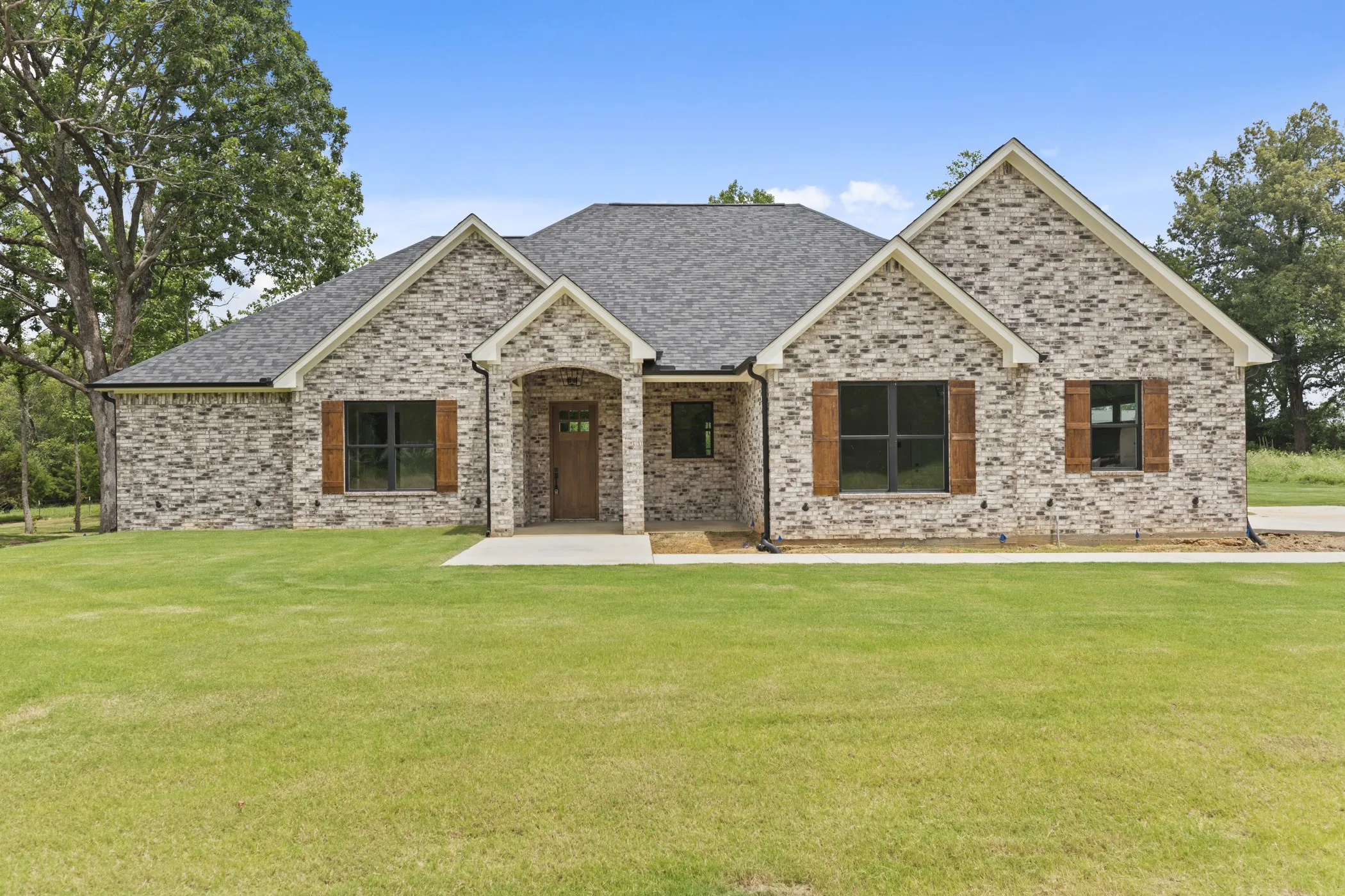 Brick exterior with gabled roof lines, dark-framed windows, and wood-finish shutters