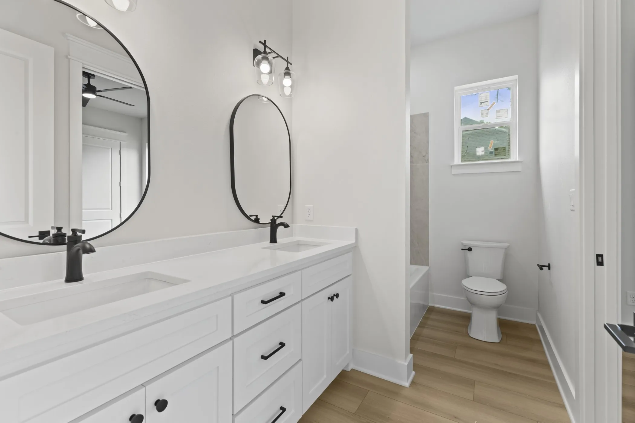 Dual vanity with white cabinetry, matte black hardware, and integrated sinks