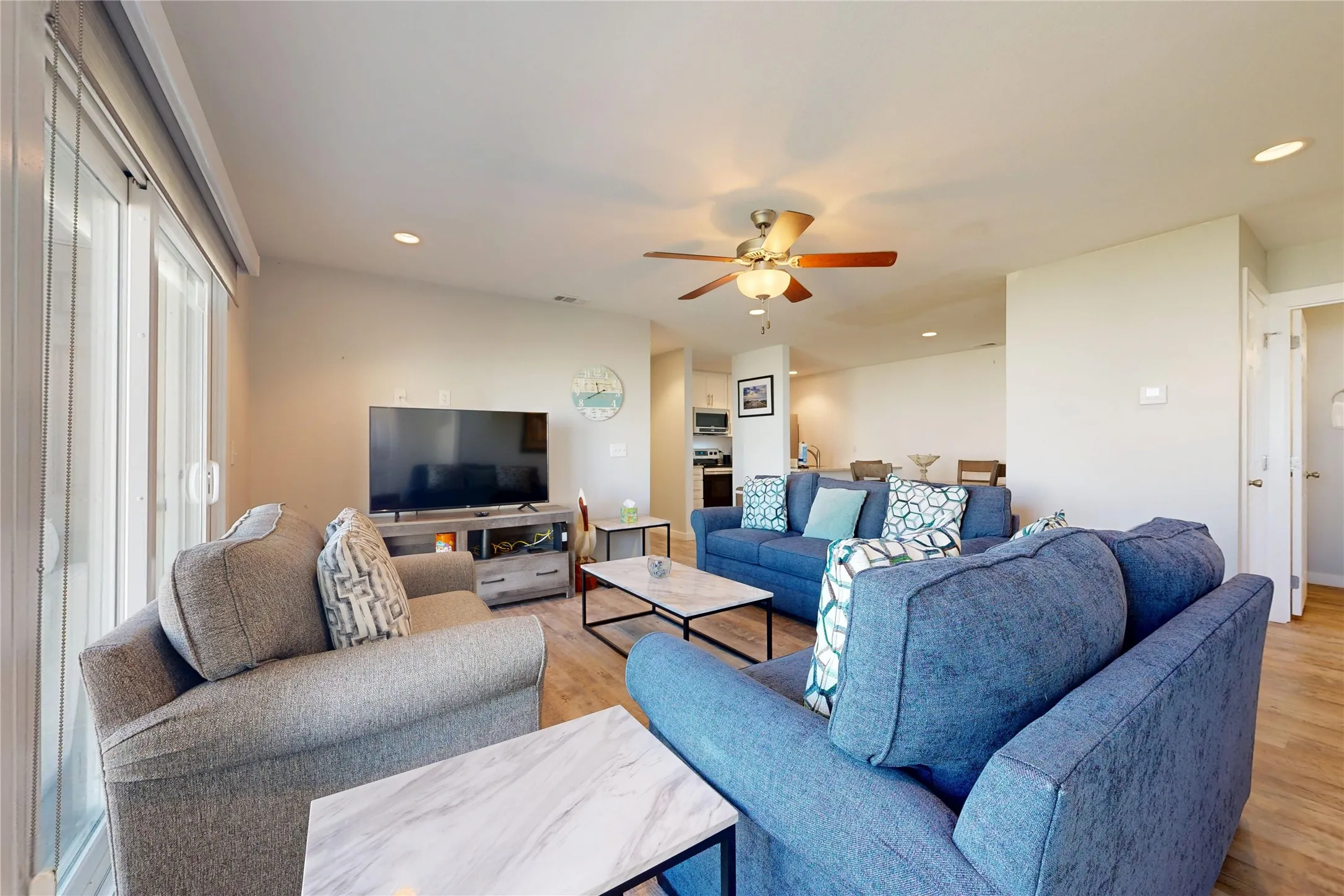 Open-concept living area featuring wood-finish flooring, recessed lighting, and a ceiling fan