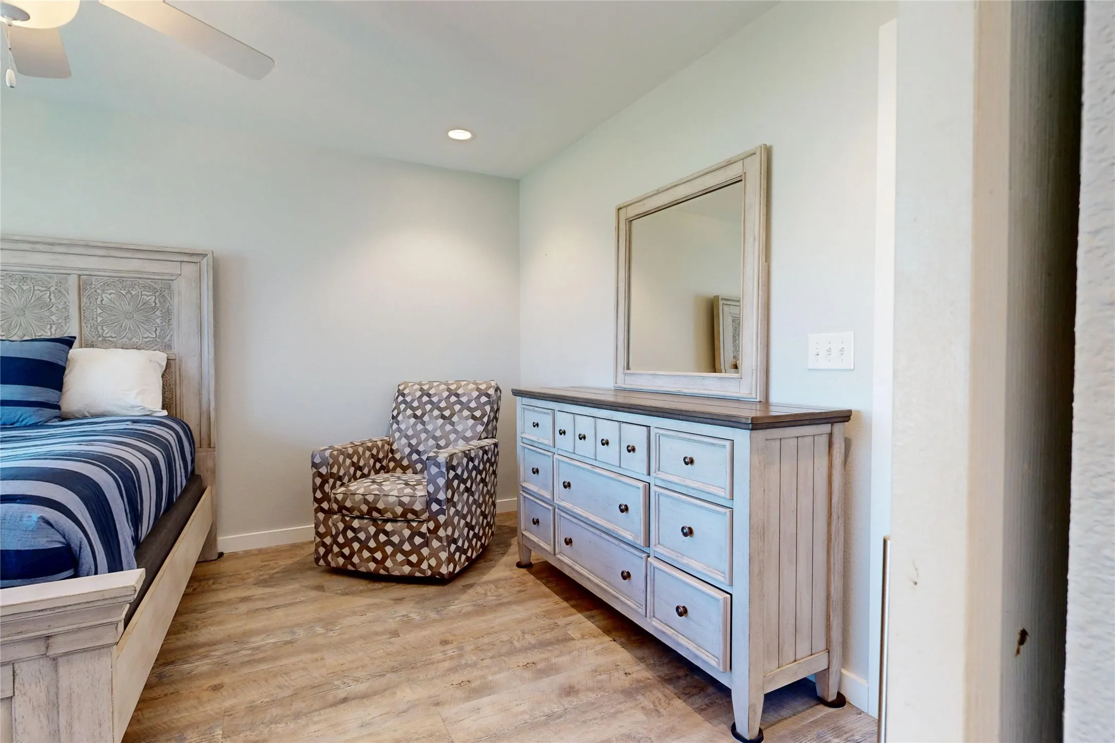 Wood-finish flooring, recessed ceiling lighting, and a ceiling fan with light fixture