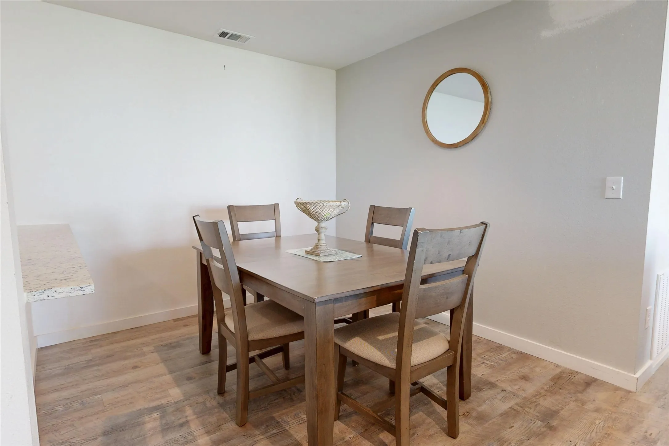 Wood-finish flooring with light-toned walls and a built-in countertop