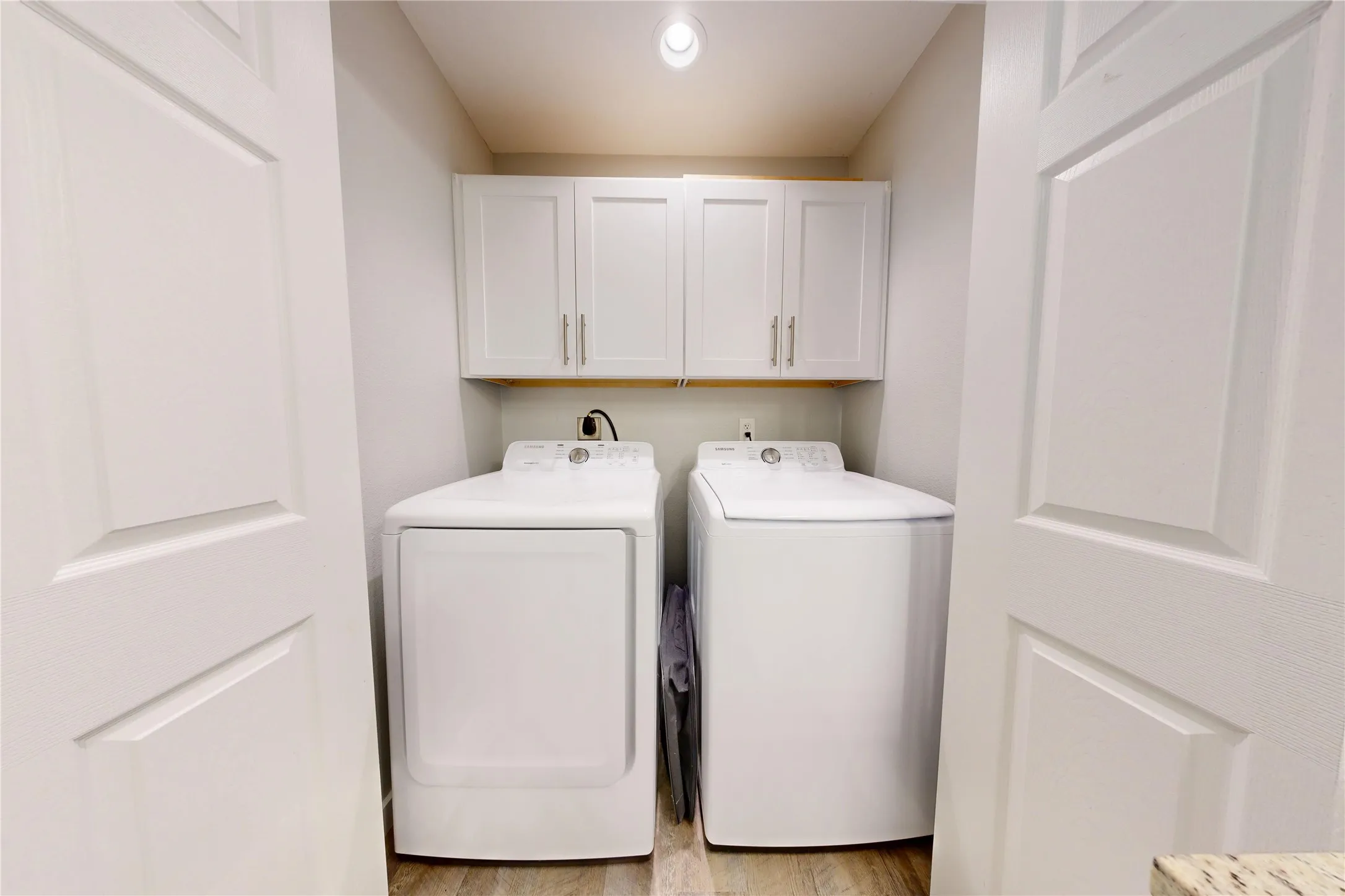 Dedicated laundry area featuring wood-finish flooring