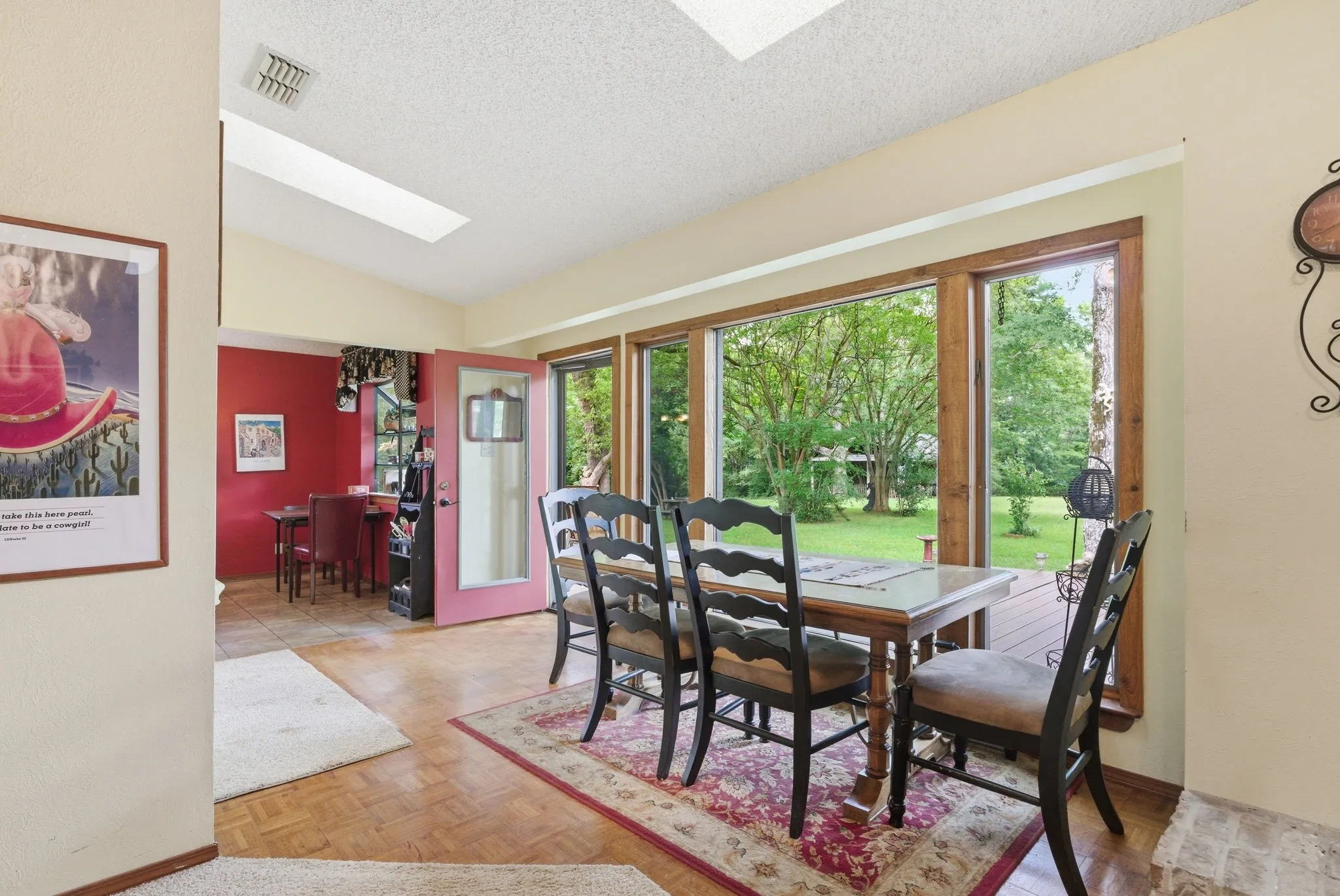 Parquet wood flooring, a skylight, and expansive windows with wood trim