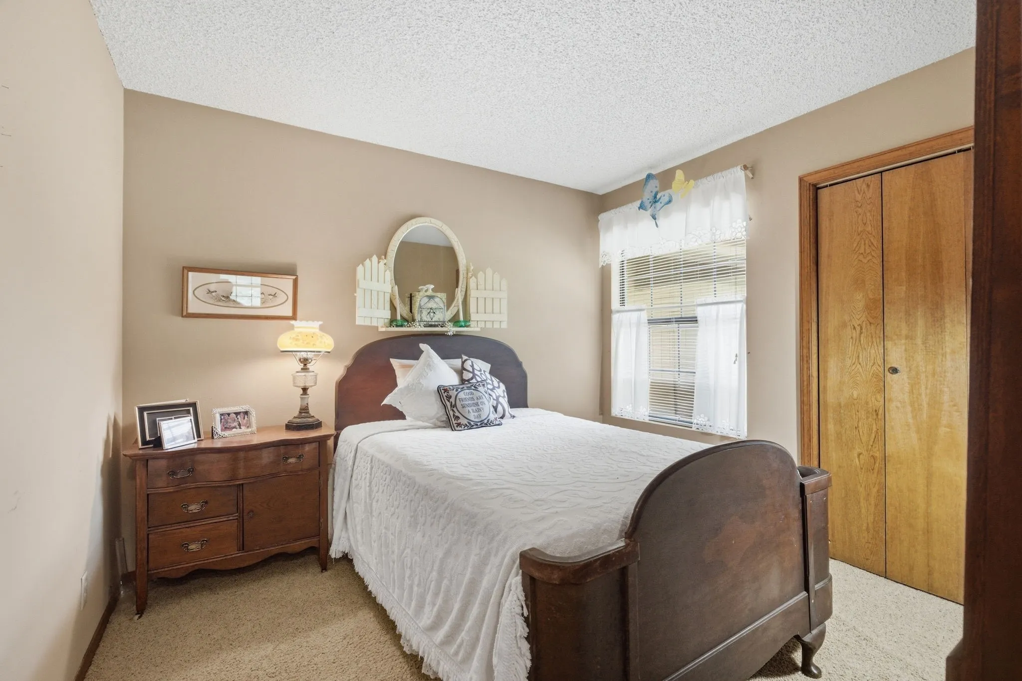 Wall-to-wall carpeting, neutral wall color, window with blinds, and bi-fold closet doors