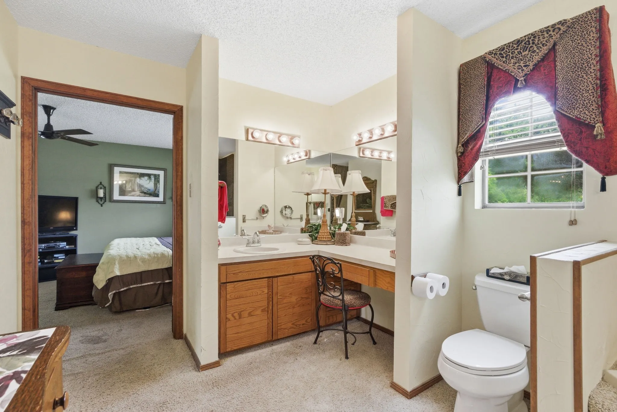 Dual vanity with integrated sinks, wood-finish cabinetry, and overhead lighting
