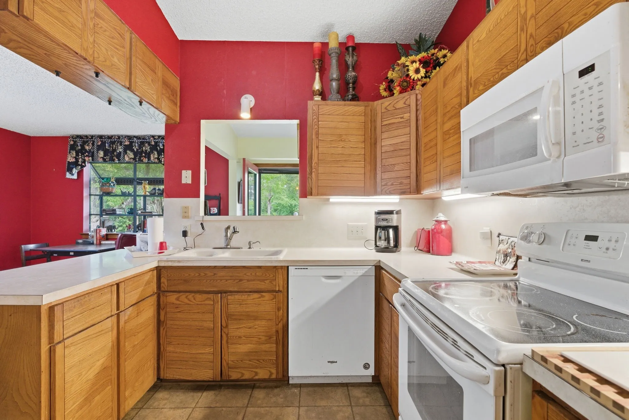 Wood-finish cabinetry paired with white countertops and white appliances