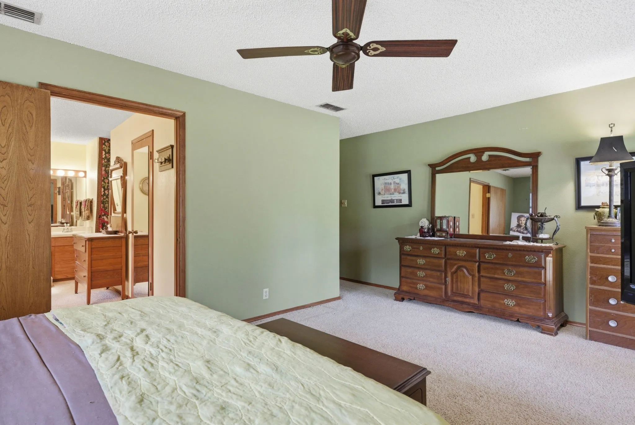Carpeted flooring, ceiling fan, and a light green wall finish