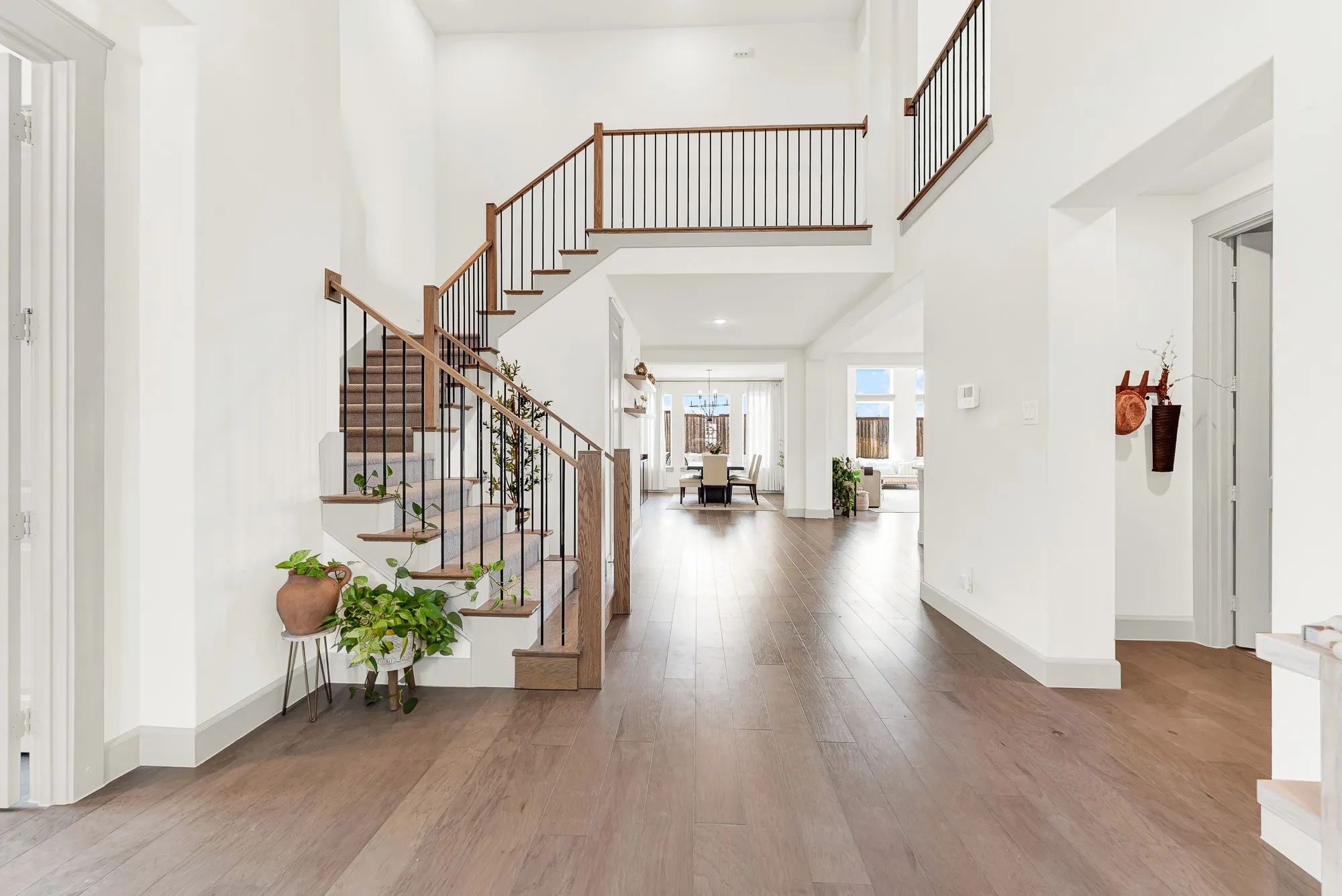 Slender iron balusters and a wrapping upper gallery create an open, airy flow down into the main living spaces below. Imagine stepping down the stairs on a quiet weekend morning, greeted by the comforting smell of fresh coffee brewing nearby