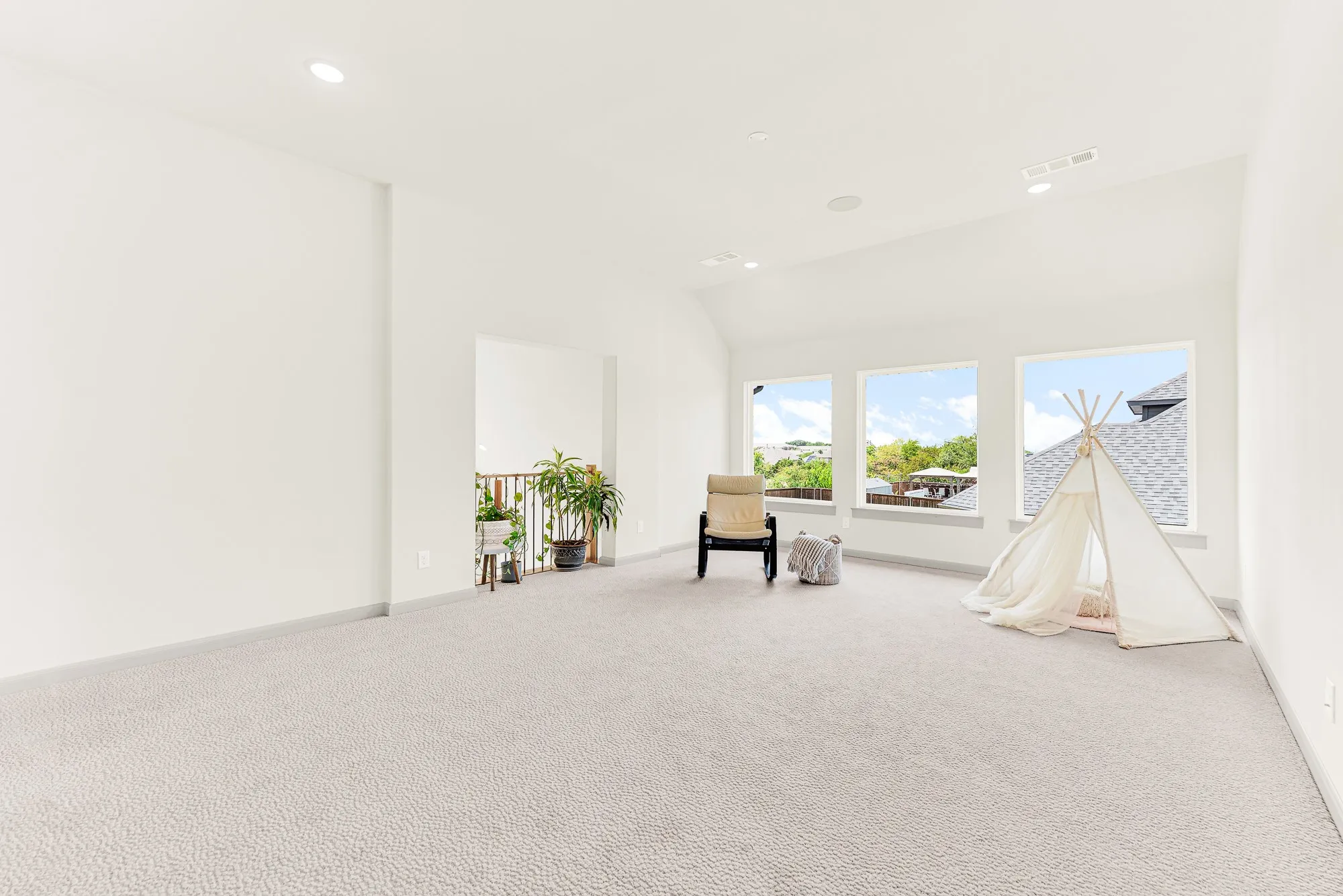 A trio of large windows fills the vaulted space with daylight and open sky views. Kids and adults alike can spend easy weekend afternoons playing board games bathed in warm sunshine