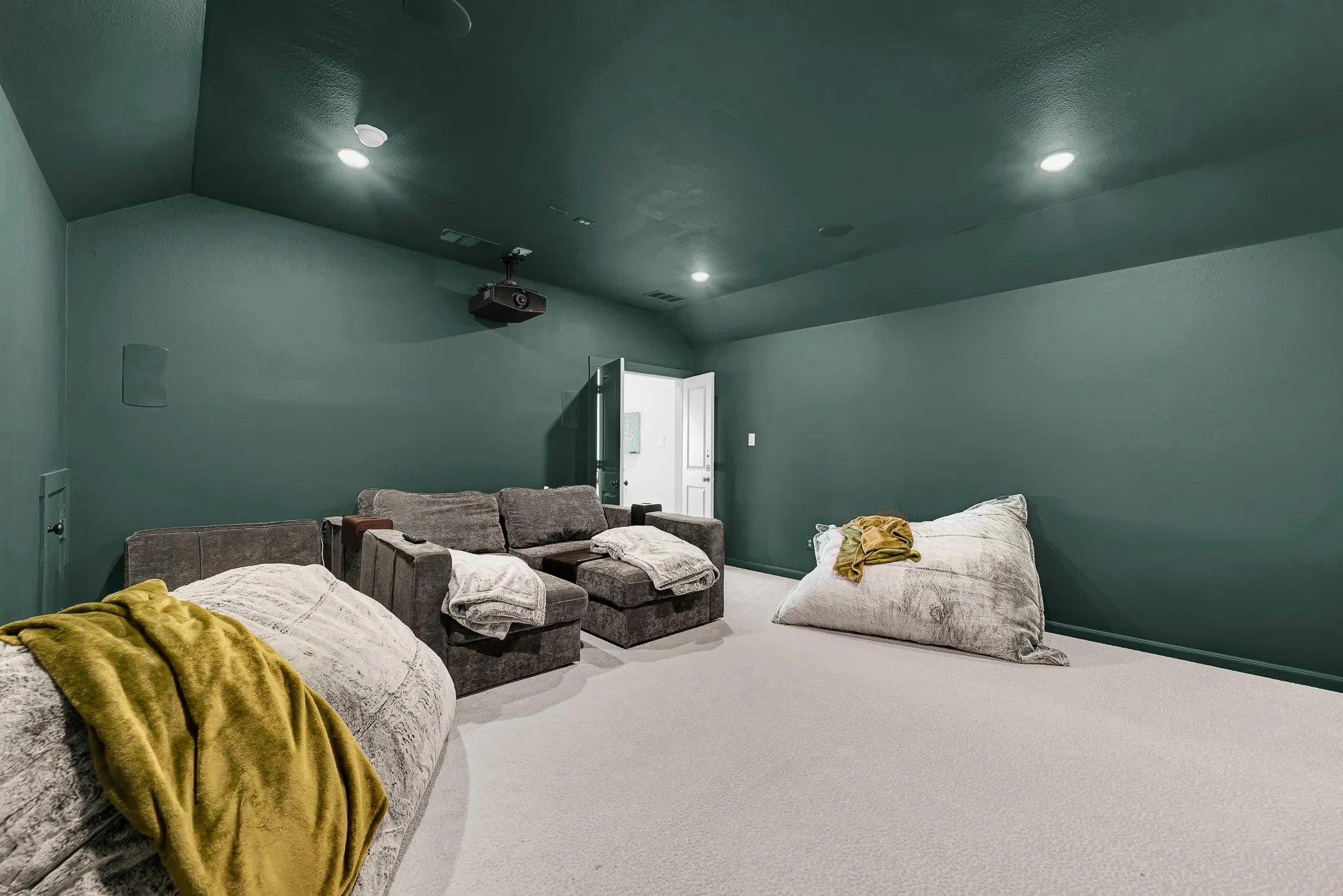 Enclosed dark surfaces and subtle recessed fixtures craft an intimate, cocoon-like atmosphere. It’s tailor-made for hosting game-day watch parties where everyone gets lost in the big-screen action.