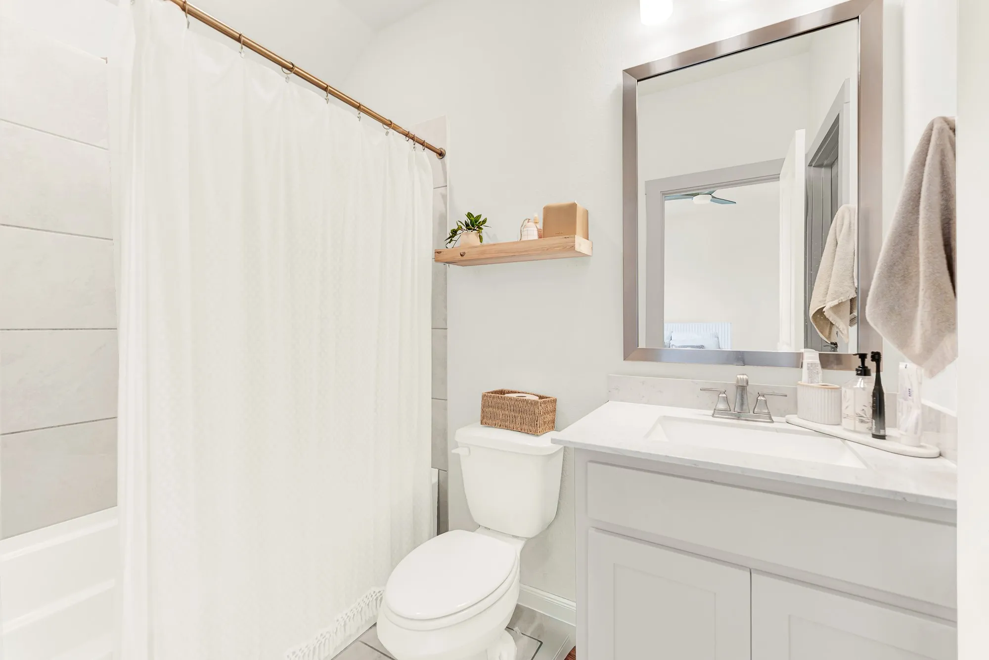 Smooth gray wall tiling around the tub creates a tailored look that reflects overhead light nicely. It’s ideal for drawing a warm, bubbly bath after a busy day of school or outdoor sports.
