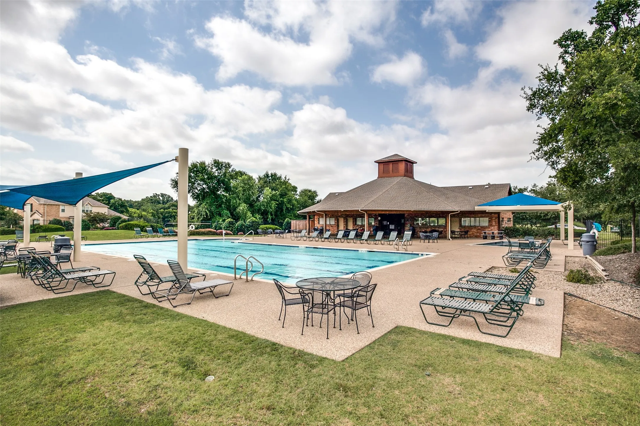 Expansive outdoor swimming pool with integrated steps and a surrounding paved deck