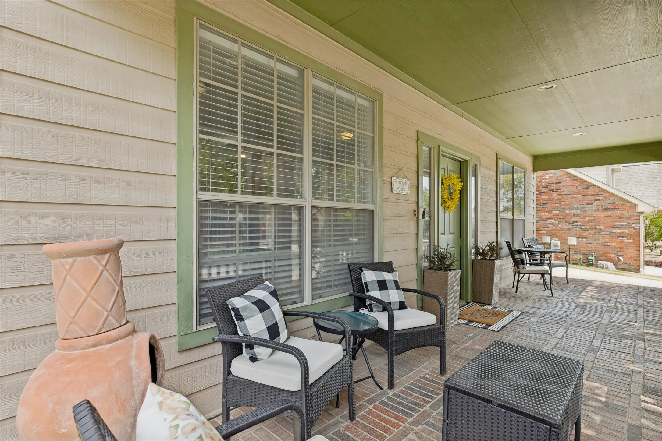 Covered patio featuring brick pavers, recessed lighting, and a paneled exterior wall