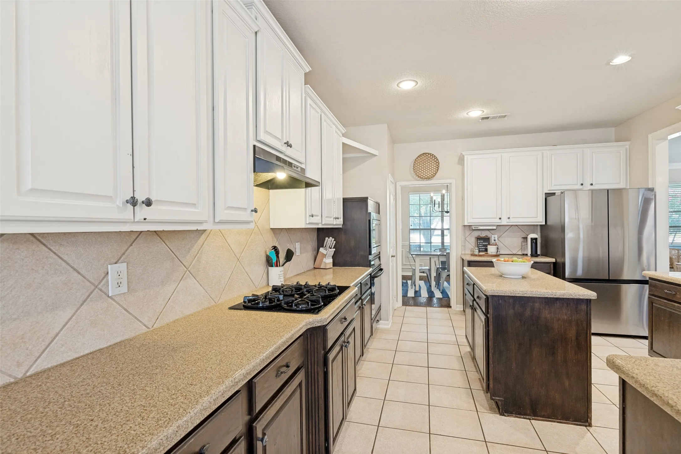 Kitchen featuring extensive cabinetry, tile flooring, a center island with countertop, stainless steel appliances, and recessed lighting