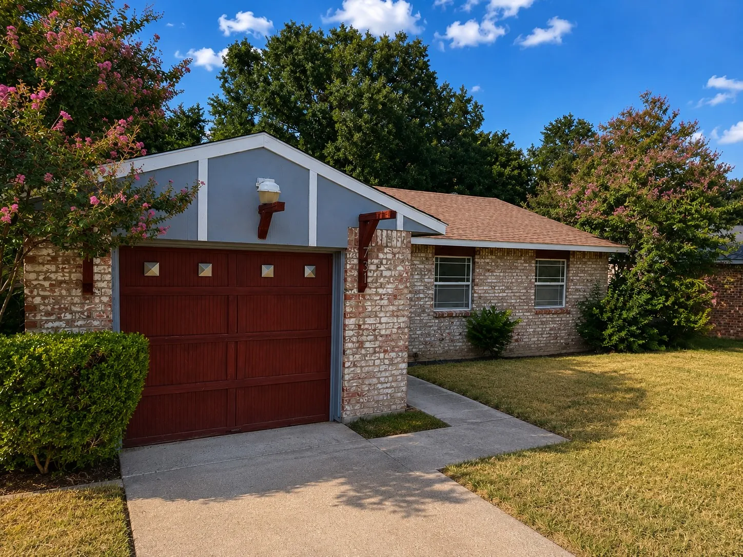 Brick exterior with a gabled roof and a rich red garage door