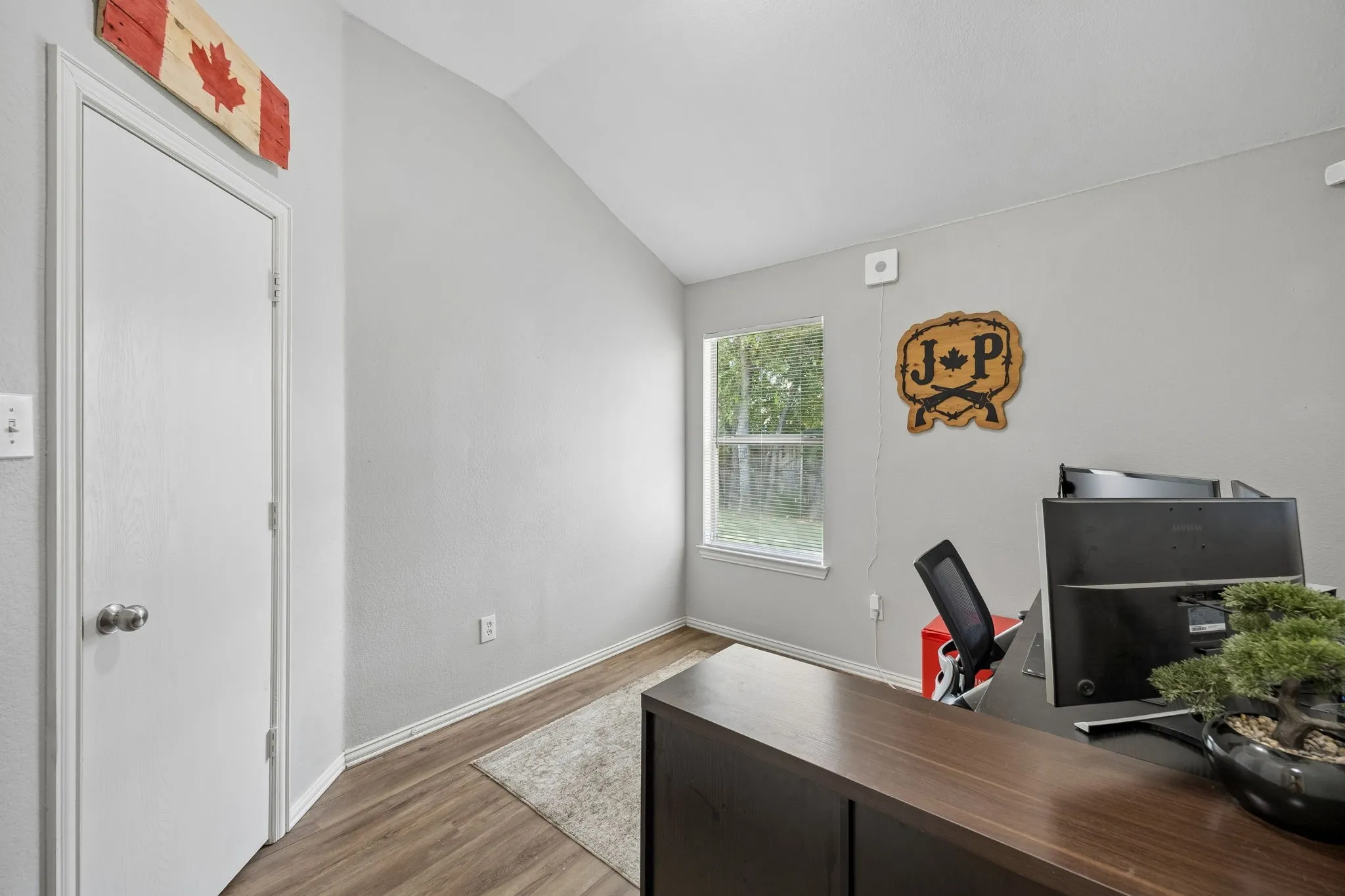 Wood-finish flooring with light-toned walls and a vaulted ceiling