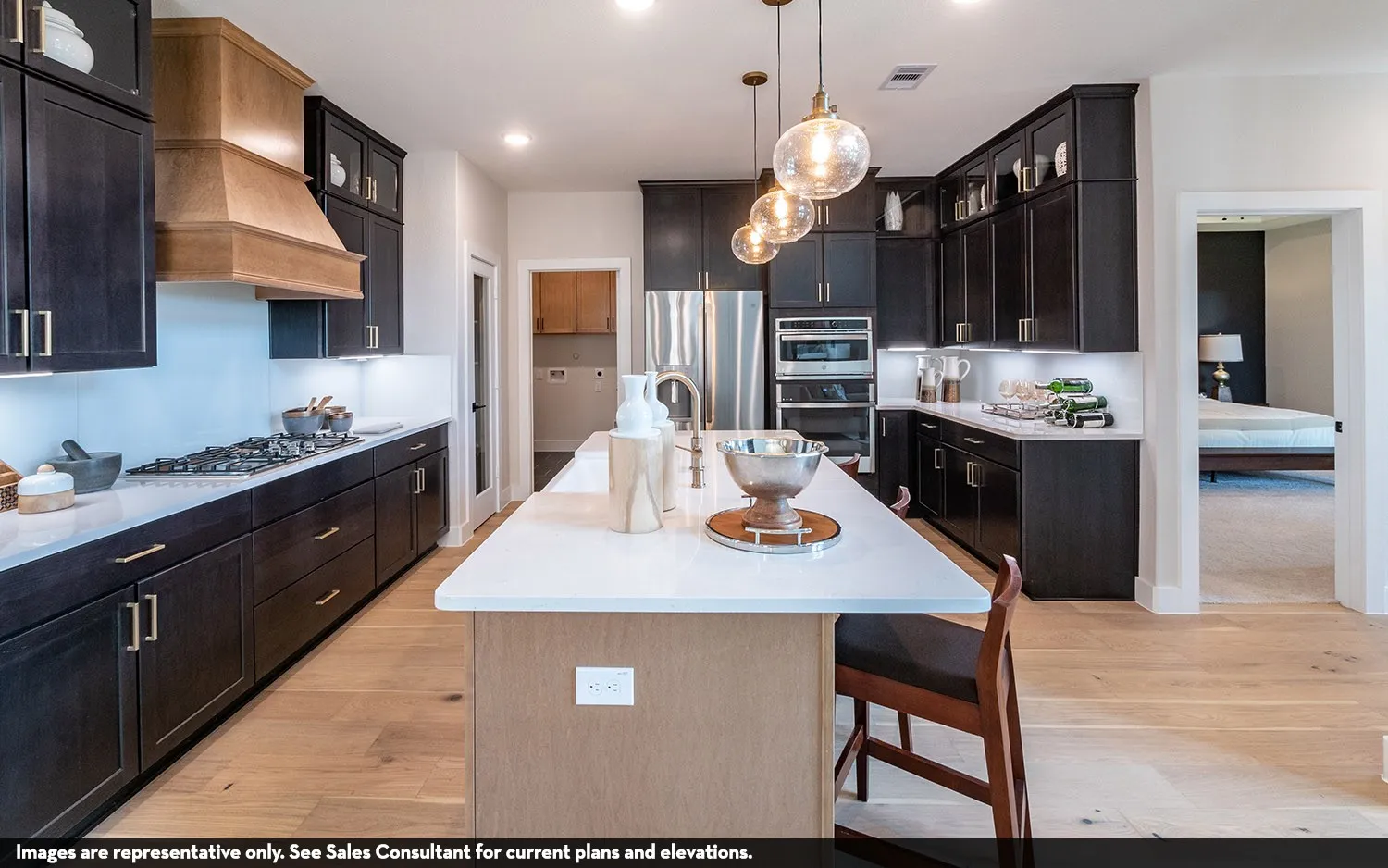 Spacious kitchen featuring dark wood cabinetry, a light wood-finish island, and light wood-finish flooring
