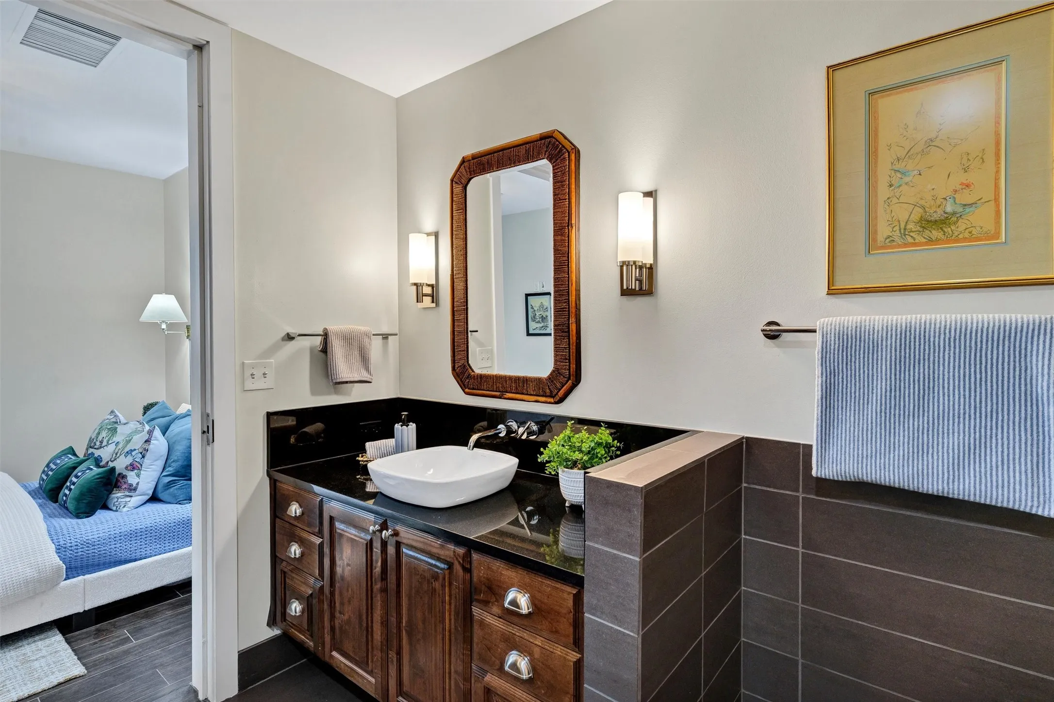 Seamless en-suite layout offering private bedroom access, generous vanity storage drawers, and a sleek vessel sink with wall-mounted plumbing.
