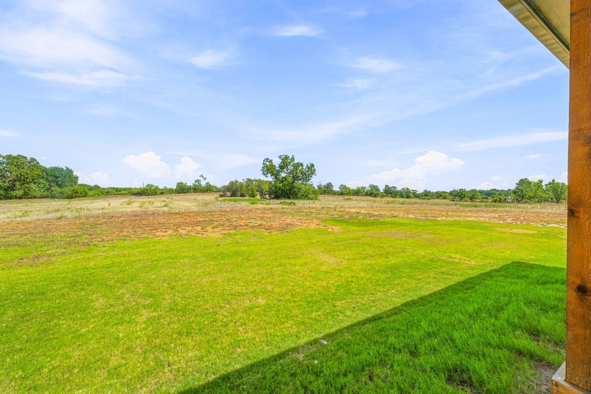 Expansive green lawn with distant trees and a natural landscape