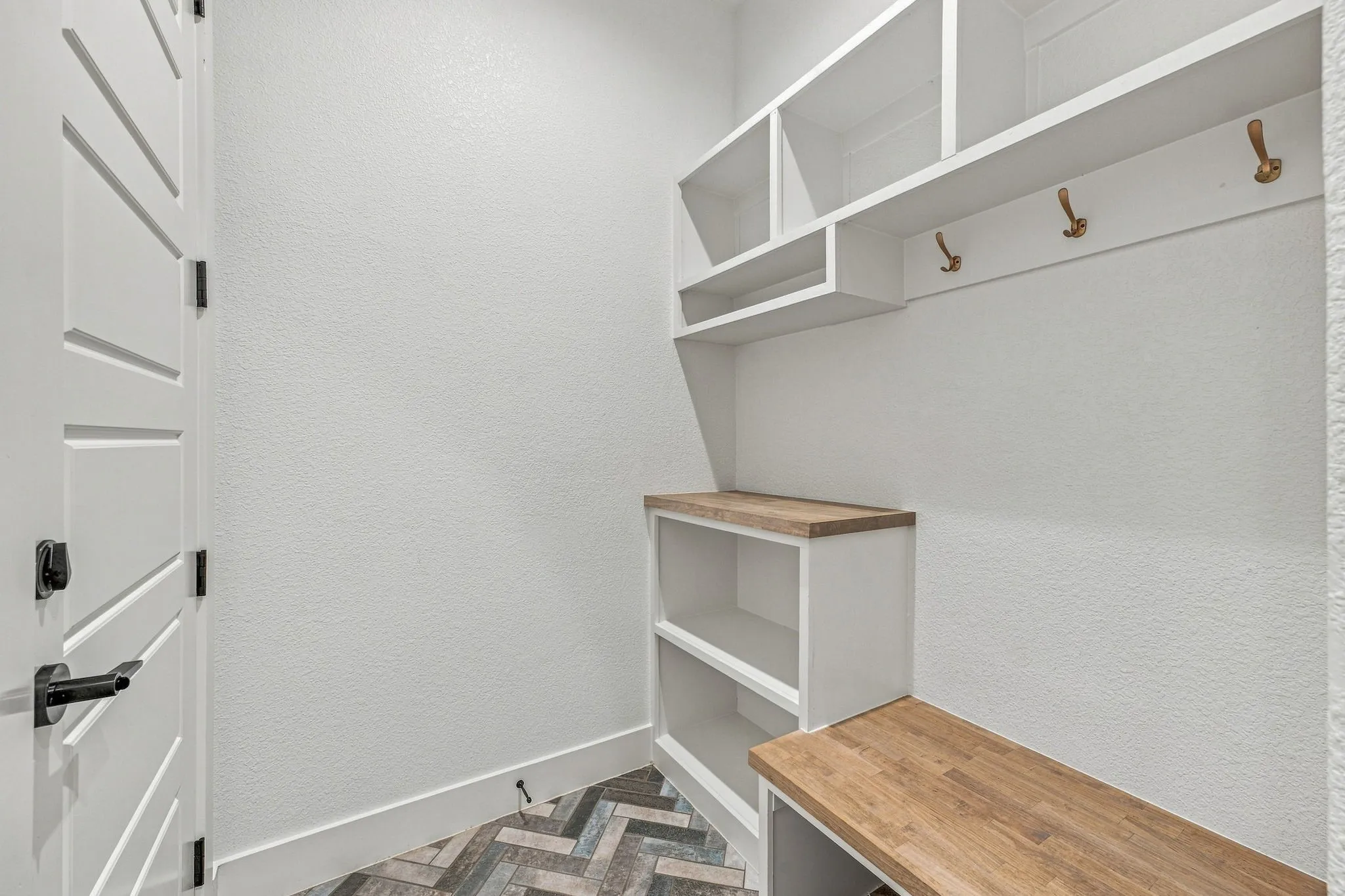 Built-in white cabinetry with wood-finish countertops and shelving