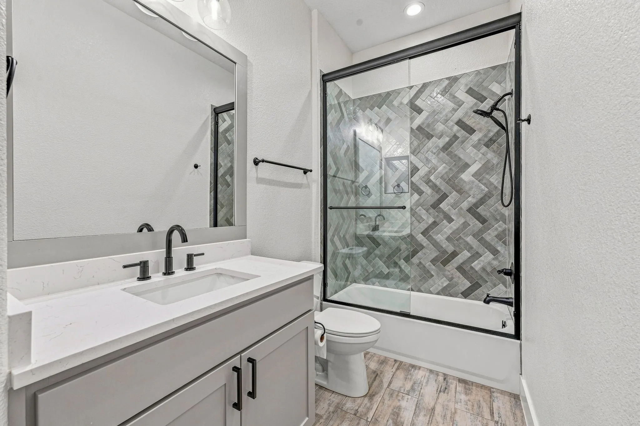 Bathroom featuring a light gray vanity with a white countertop, an undermount sink, and matte black fixtures