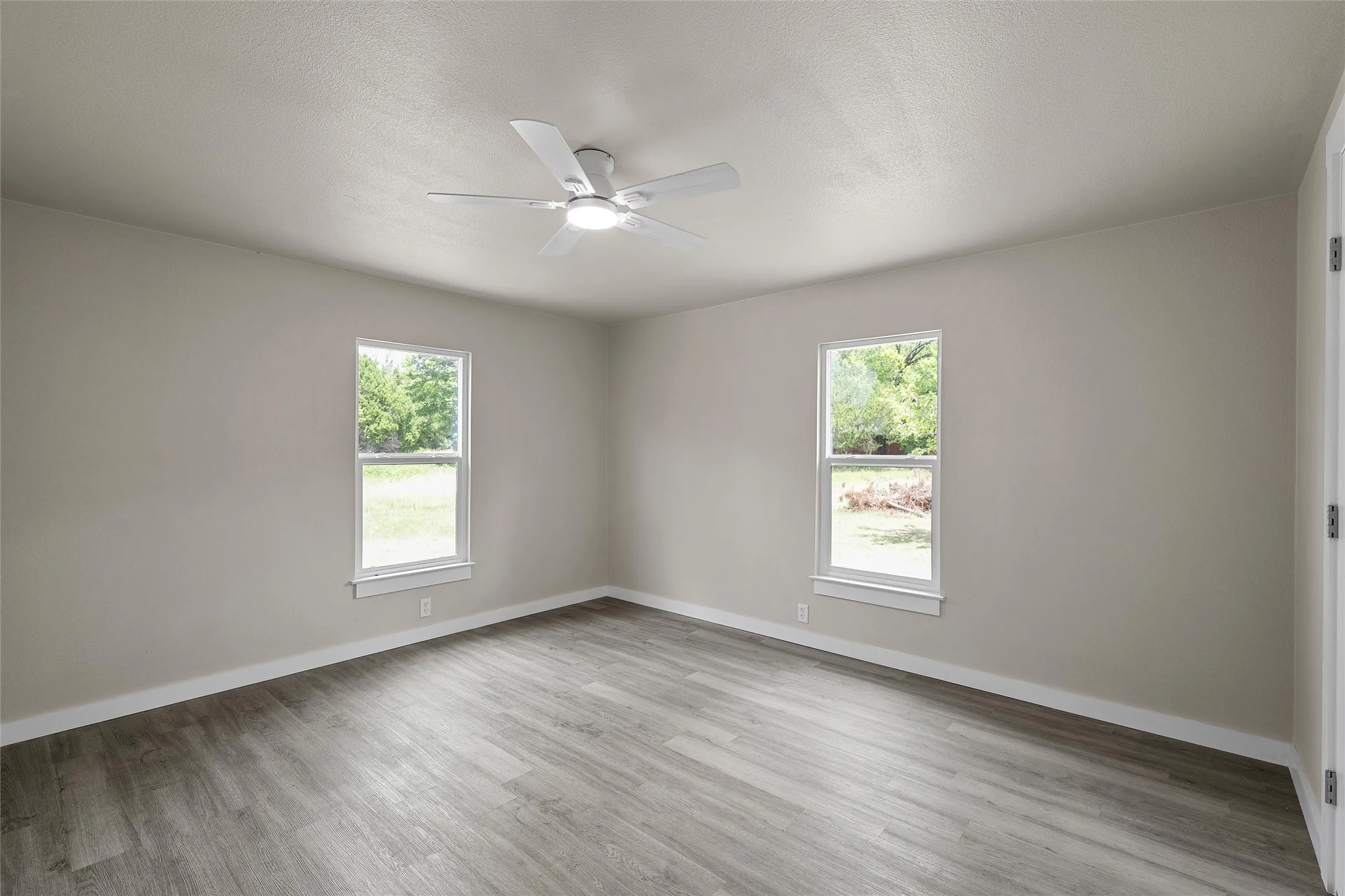 Wood-finish flooring, light-toned walls, and recessed lighting with a ceiling fan