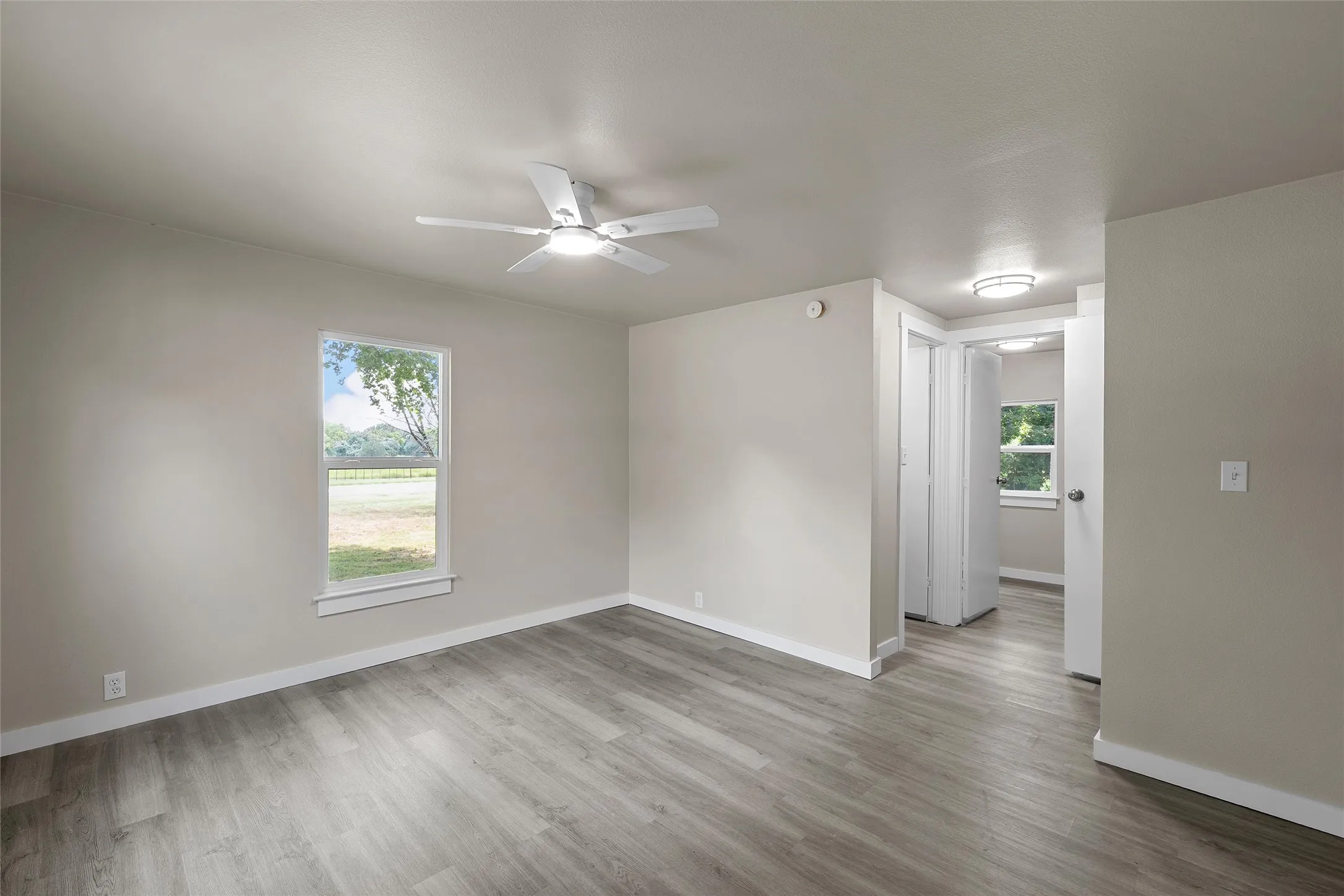 Wood-finish flooring throughout, ceiling fan with integrated lighting, recessed lighting, and a white-trimmed​​‌​​​​‌​​‌‌​‌‌​​​‌‌​‌​‌​‌​​​‌​​ window