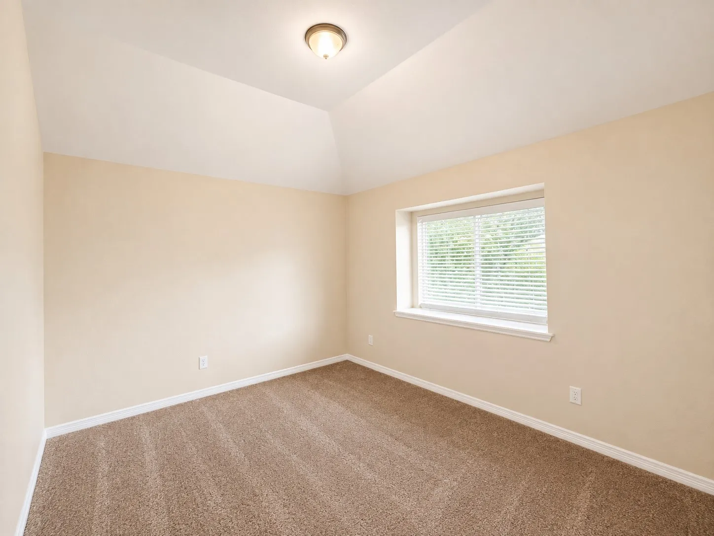 Vaulted ceiling, neutral wall paint, window with blinds, and textured carpeting