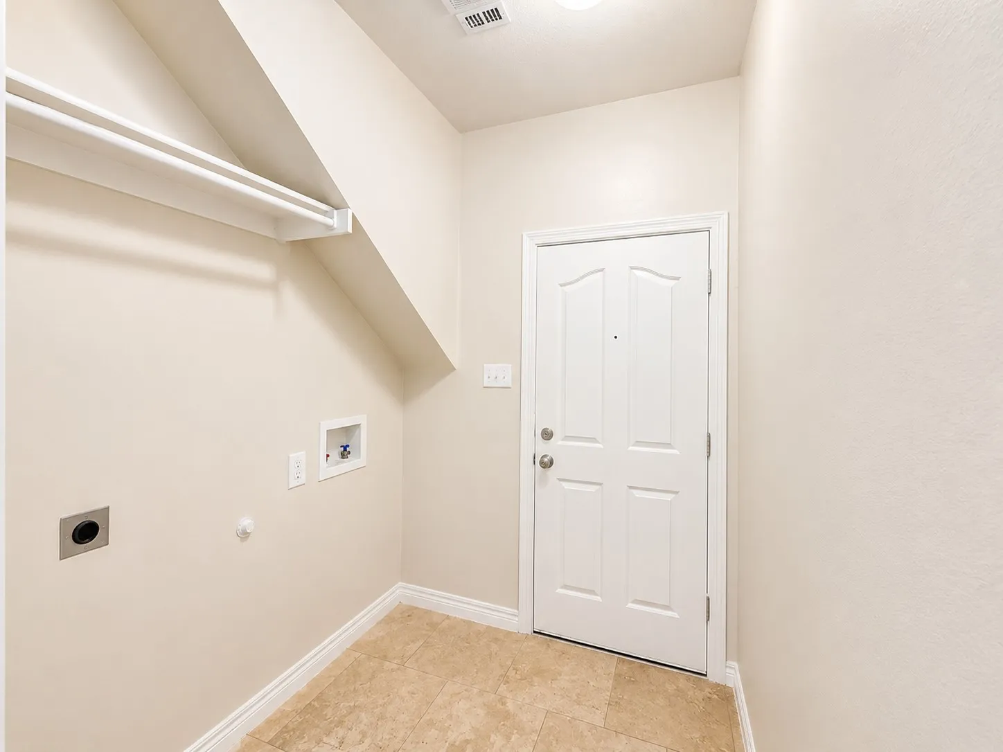 Laundry area featuring a paneled door, tile flooring, and wall-mounted shelving