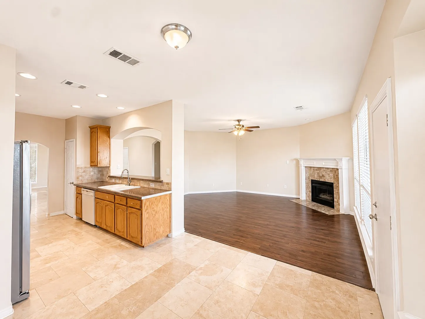 Kitchen featuring wood-finish cabinetry, a drop-in sink, and a tiled backsplash