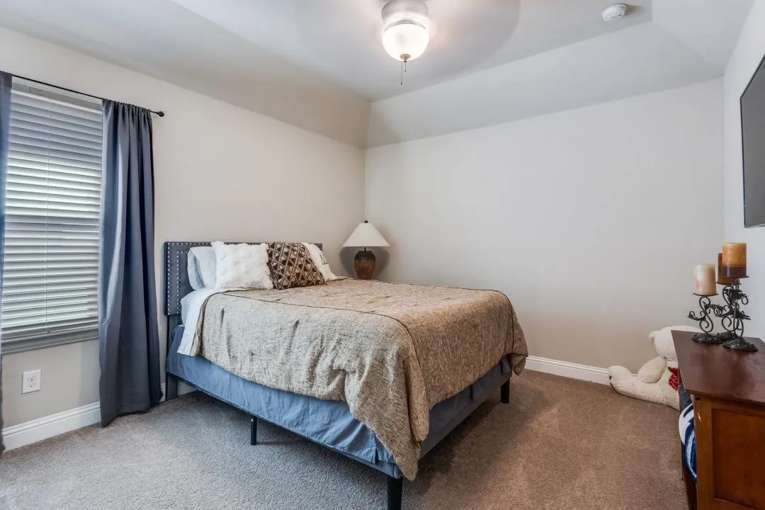 Plush carpeted flooring, a tray ceiling, and a ceiling fan with integrated lighting