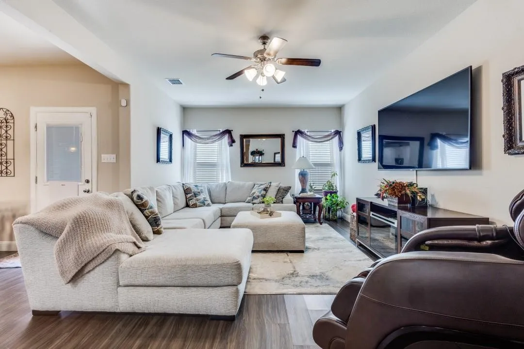 Recessed lighting, ceiling fan light fixture, wood-finish flooring, white trim, and a built-in media console